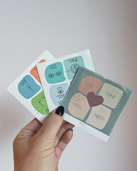 Hand holding a set of small stickers with various symbols and text on a light background